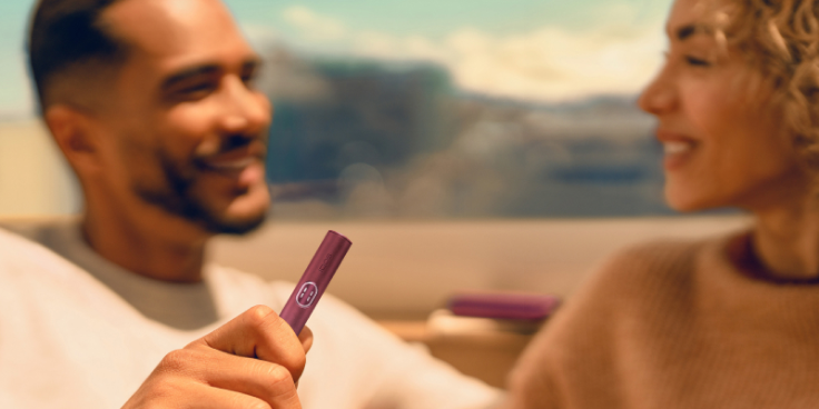 Man holding a Garnet Red IQOS ILUMA i PRIME device